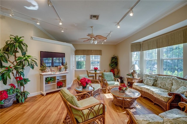 living area featuring track lighting, ornamental molding, visible vents, a ceiling fan, and light wood-style flooring