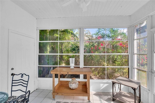 sunroom featuring tile patterned floors, a healthy amount of sunlight, and ceiling fan