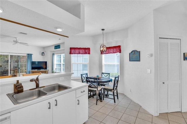 kitchen with a sink, white cabinets, plenty of natural light, and visible vents