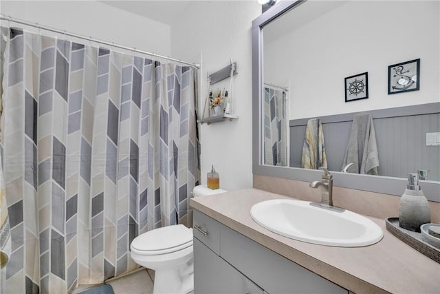 bathroom with vanity, tile patterned flooring, toilet, and curtained shower
