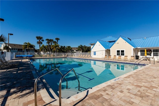community pool with fence and a patio area