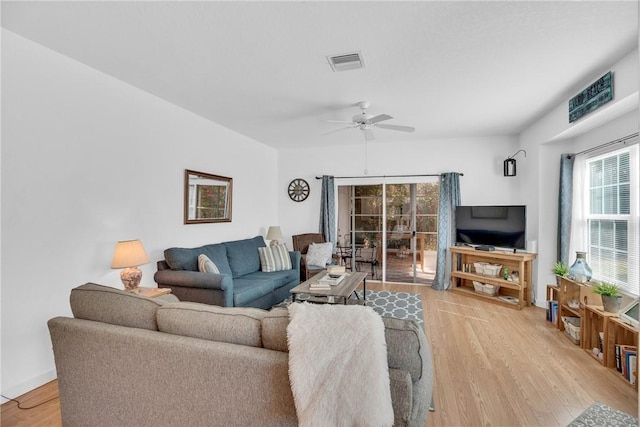 living area featuring visible vents, plenty of natural light, ceiling fan, and light wood-type flooring