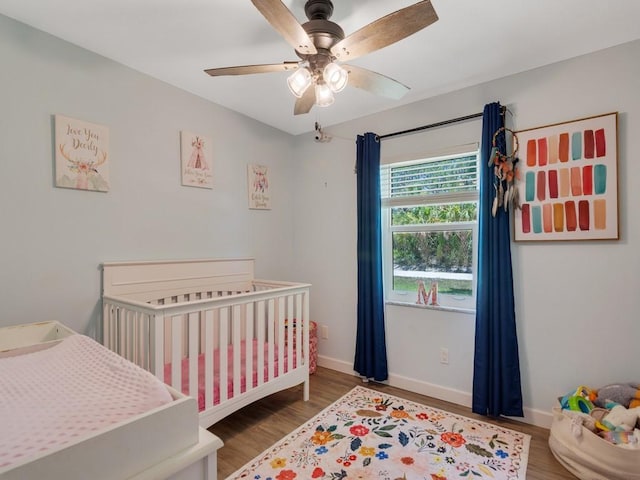 6345 7th Ln, Vero Beach, FL 32968 - bedroom featuring a crib, wood finished floors, and a ceiling fan