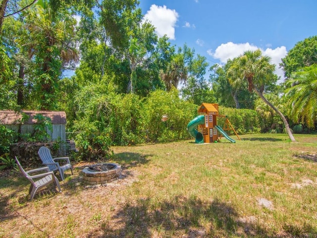6345 7th Ln, Vero Beach, FL 32968 - view of green lawn with a playground and an outdoor fire pit