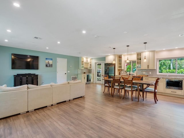 6345 7th Ln, Vero Beach, FL 32968 - living room featuring beverage cooler, light wood-style flooring, and recessed lighting