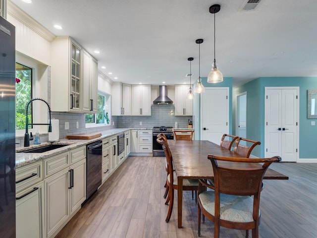 6345 7th Ln, Vero Beach, FL 32968 - kitchen with stainless steel appliances, wall chimney exhaust hood, decorative backsplash, light wood-style floors, and recessed lighting