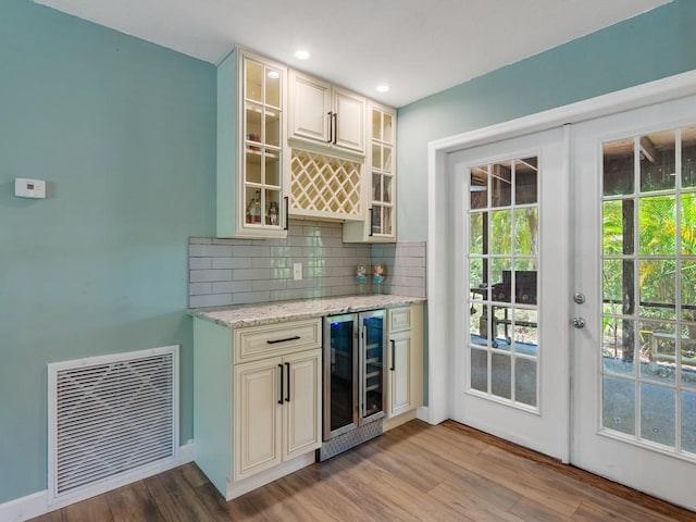 6345 7th Ln, Vero Beach, FL 32968 - indoor dry bar with beverage cooler, wood finished floors, backsplash, french doors, and recessed lighting