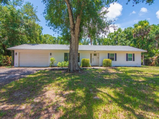 6345 7th Ln, Vero Beach, FL 32968 - single story home with stucco siding, driveway, an attached garage, and a front yard