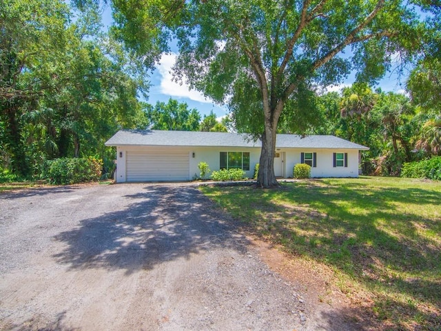 6345 7th Ln, Vero Beach, FL 32968 - ranch-style house with driveway, a garage, a front lawn, and stucco siding