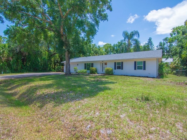 6345 7th Ln, Vero Beach, FL 32968 - ranch-style house with a front yard, stucco siding, asphalt driveway, and a garage