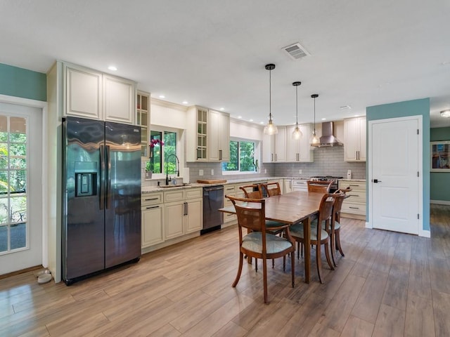6345 7th Ln, Vero Beach, FL 32968 - kitchen with fridge with ice dispenser, wall chimney range hood, dishwashing machine, tasteful backsplash, and light wood finished floors