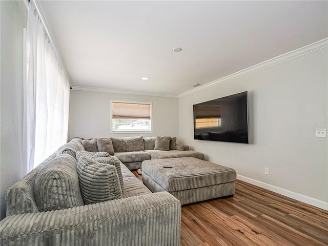 living area with baseboards, crown molding, wood finished floors, and recessed lighting