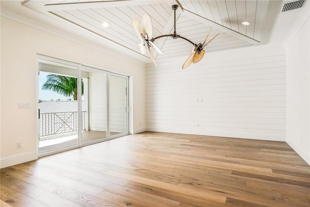 empty room with visible vents, wooden ceiling, baseboards, and wood finished floors