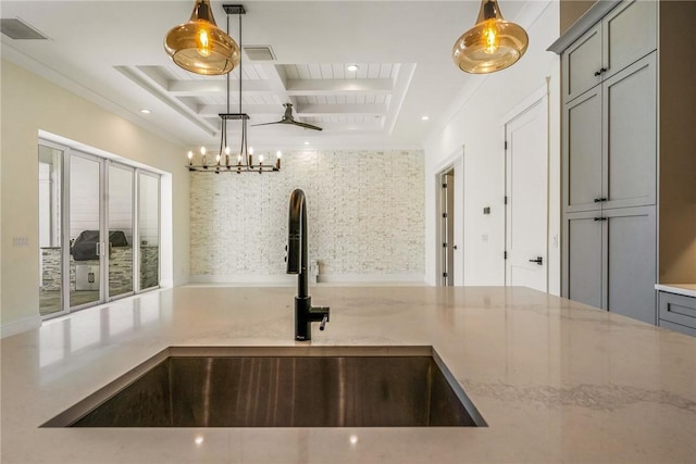 kitchen featuring a sink, visible vents, light stone counters, and gray cabinetry