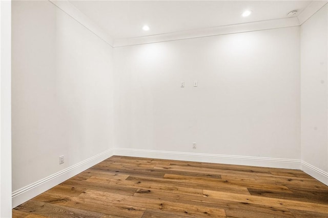 empty room featuring recessed lighting, crown molding, baseboards, and wood-type flooring