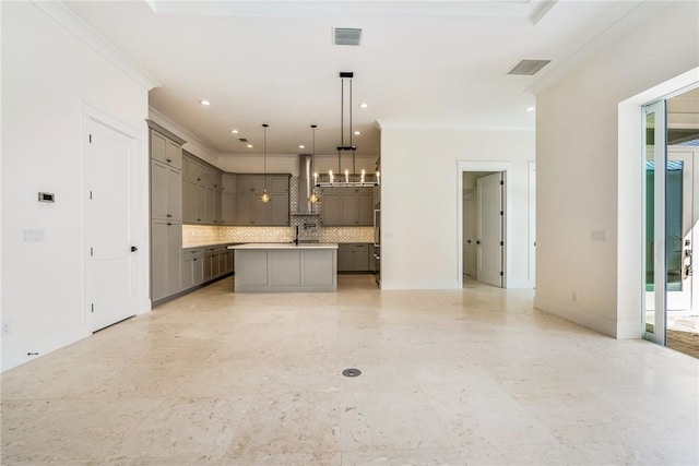 kitchen with visible vents, an island with sink, gray cabinets, decorative backsplash, and crown molding