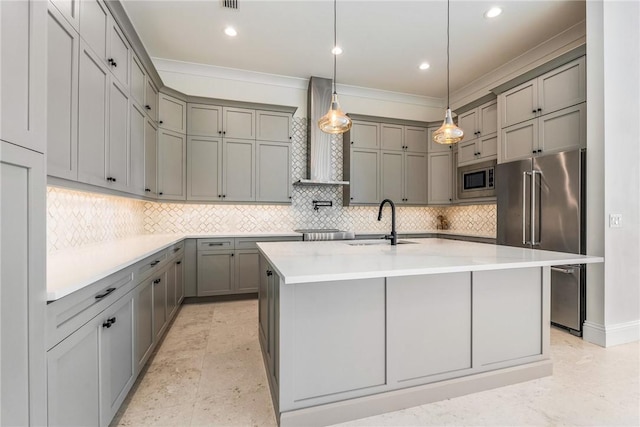 kitchen with ornamental molding, gray cabinets, a sink, appliances with stainless steel finishes, and wall chimney exhaust hood