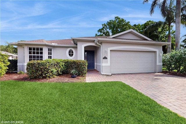 652 Hatteras Ct SW, Vero Beach, FL 32968 - ranch-style home featuring stucco siding, a front yard, an attached garage, and driveway