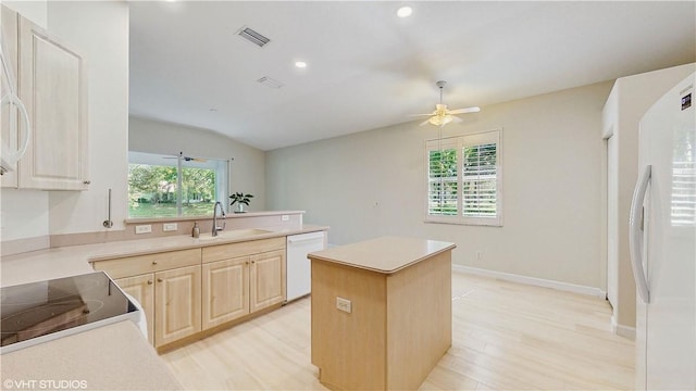 652 Hatteras Ct SW, Vero Beach, FL 32968 - kitchen with visible vents, light brown cabinets, a kitchen island, white appliances, and a sink