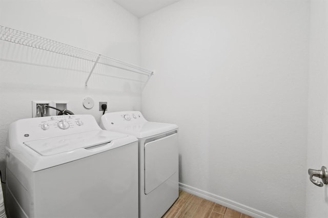 laundry area featuring light hardwood / wood-style floors and washing machine and clothes dryer