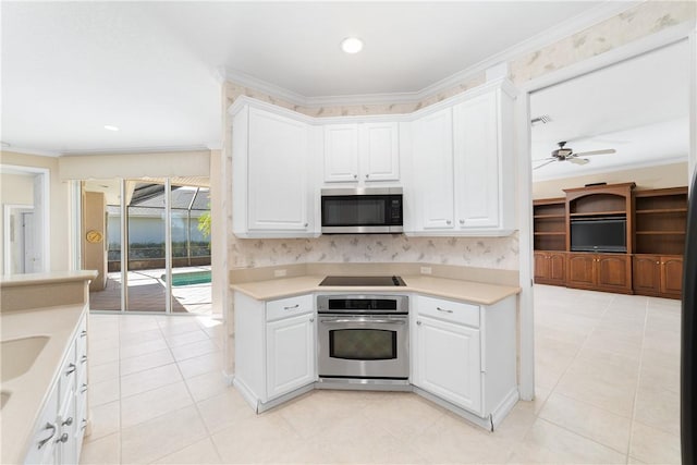 kitchen with crown molding, light tile patterned floors, appliances with stainless steel finishes, ceiling fan, and white cabinets