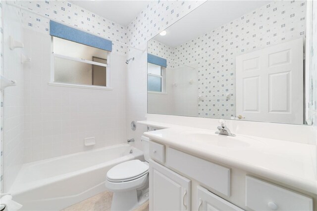 full bathroom featuring tile patterned flooring, vanity, tiled shower / bath combo, and toilet