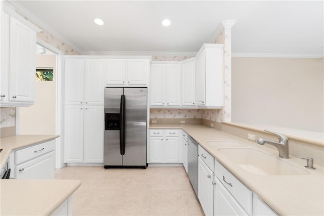 kitchen with white cabinetry, ornamental molding, appliances with stainless steel finishes, and sink