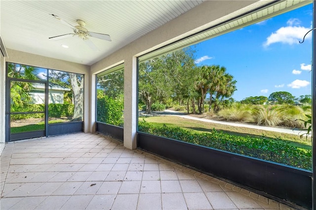 unfurnished sunroom featuring ceiling fan