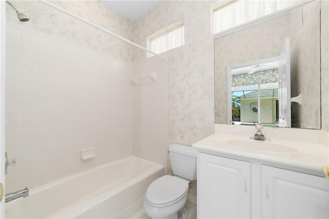 full bathroom with tiled shower / bath, vanity, and toilet