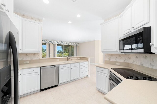 kitchen featuring stainless steel appliances, kitchen peninsula, sink, and white cabinets