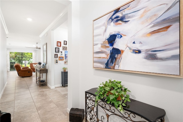 hall featuring light tile patterned floors and ornamental molding