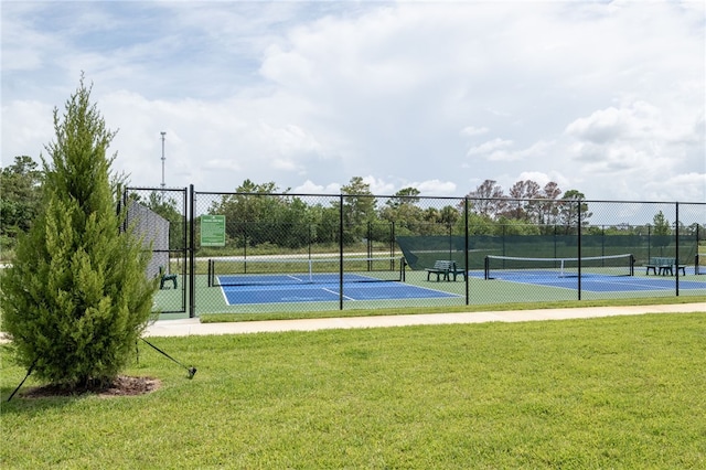 view of tennis court featuring a yard