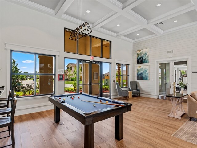 game room featuring french doors, a towering ceiling, beamed ceiling, hardwood / wood-style floors, and pool table