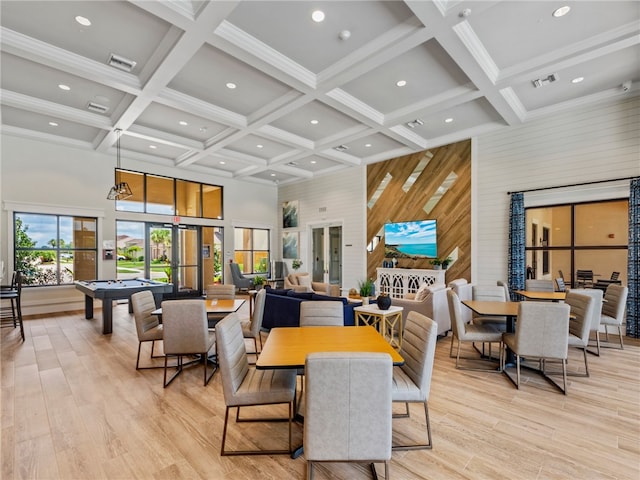 dining space with coffered ceiling, billiards, beamed ceiling, a high ceiling, and light hardwood / wood-style floors