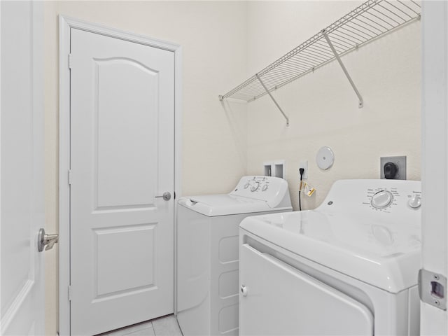 laundry room featuring washer and clothes dryer and light tile patterned flooring