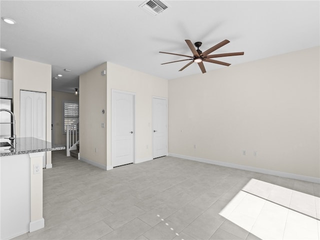 unfurnished living room with ceiling fan and light tile patterned flooring