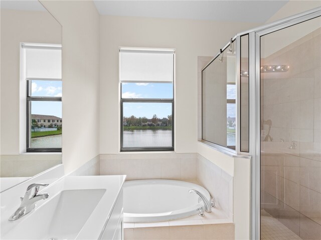 bathroom with a water view, sink, and independent shower and bath