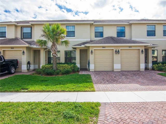 view of property featuring a garage and a front yard