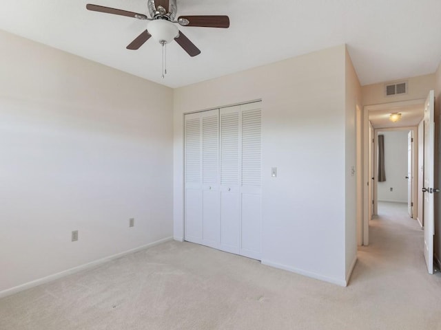 unfurnished bedroom featuring ceiling fan, light carpet, and a closet