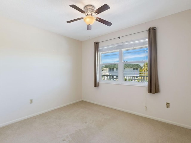 carpeted spare room with ceiling fan