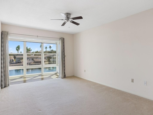 carpeted empty room featuring ceiling fan