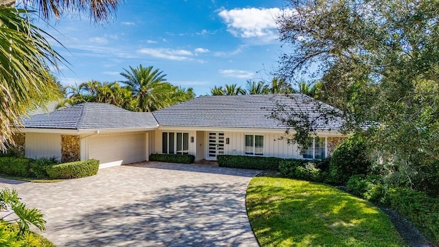 ranch-style house with a garage and a front yard