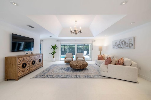 living room with an inviting chandelier and a tray ceiling