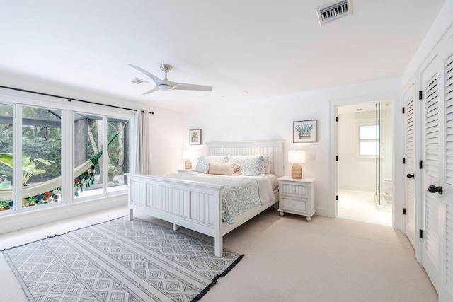 carpeted bedroom featuring ensuite bath and ceiling fan