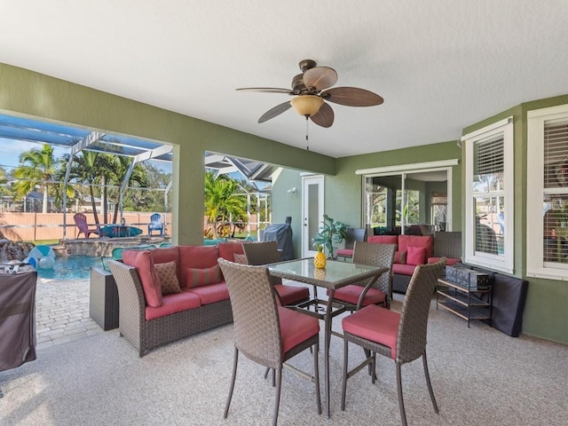 view of patio / terrace featuring pool water feature, a swimming pool with hot tub, a lanai, ceiling fan, and an outdoor living space