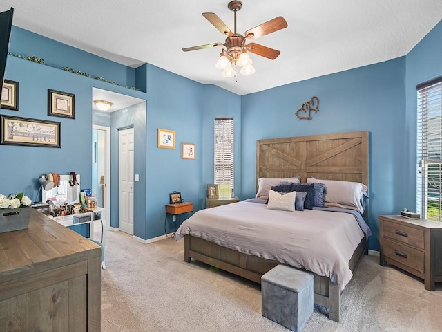 bedroom featuring light carpet, lofted ceiling, and ceiling fan