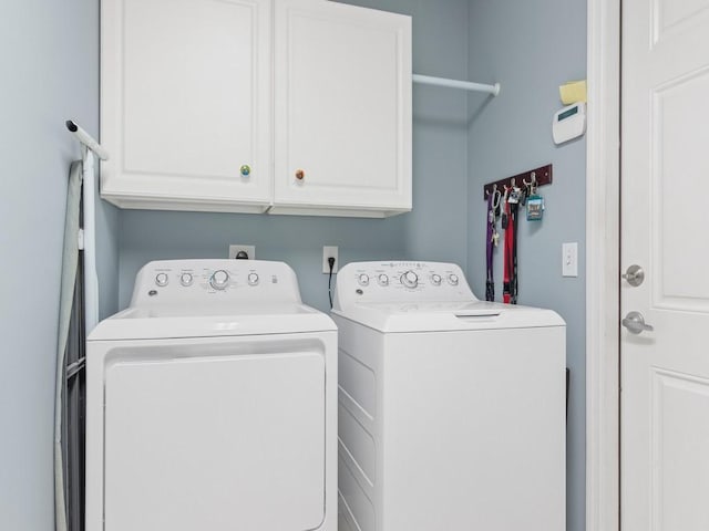 washroom featuring washer and clothes dryer and cabinets