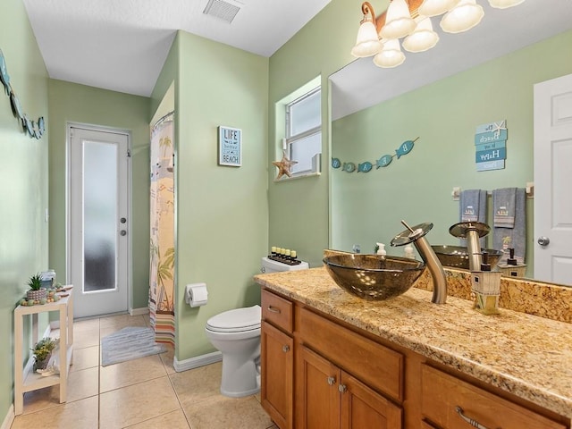 bathroom featuring tile patterned flooring, vanity, a notable chandelier, and toilet