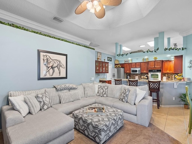 tiled living room featuring ornamental molding and ceiling fan