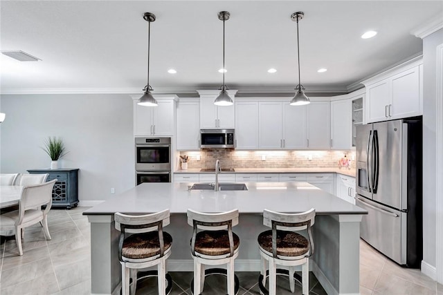 kitchen with sink, a center island with sink, pendant lighting, and appliances with stainless steel finishes